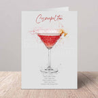 Greeting card with a cosmopolitan cocktail illustration on a wooden surface.