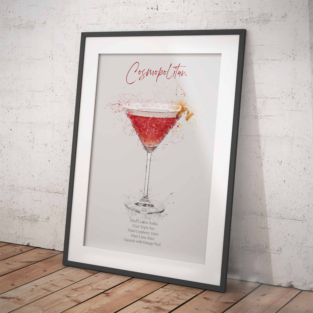 Framed print of a Cosmopolitan cocktail recipe on a white wall.