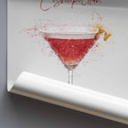 Art print of a Cosmopolitan cocktail in a martini glass with splashes on a gray background.