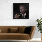 Framed portrait of James Bond, Daniel Craig holding a glass above a brown sofa with decorative pillows.
