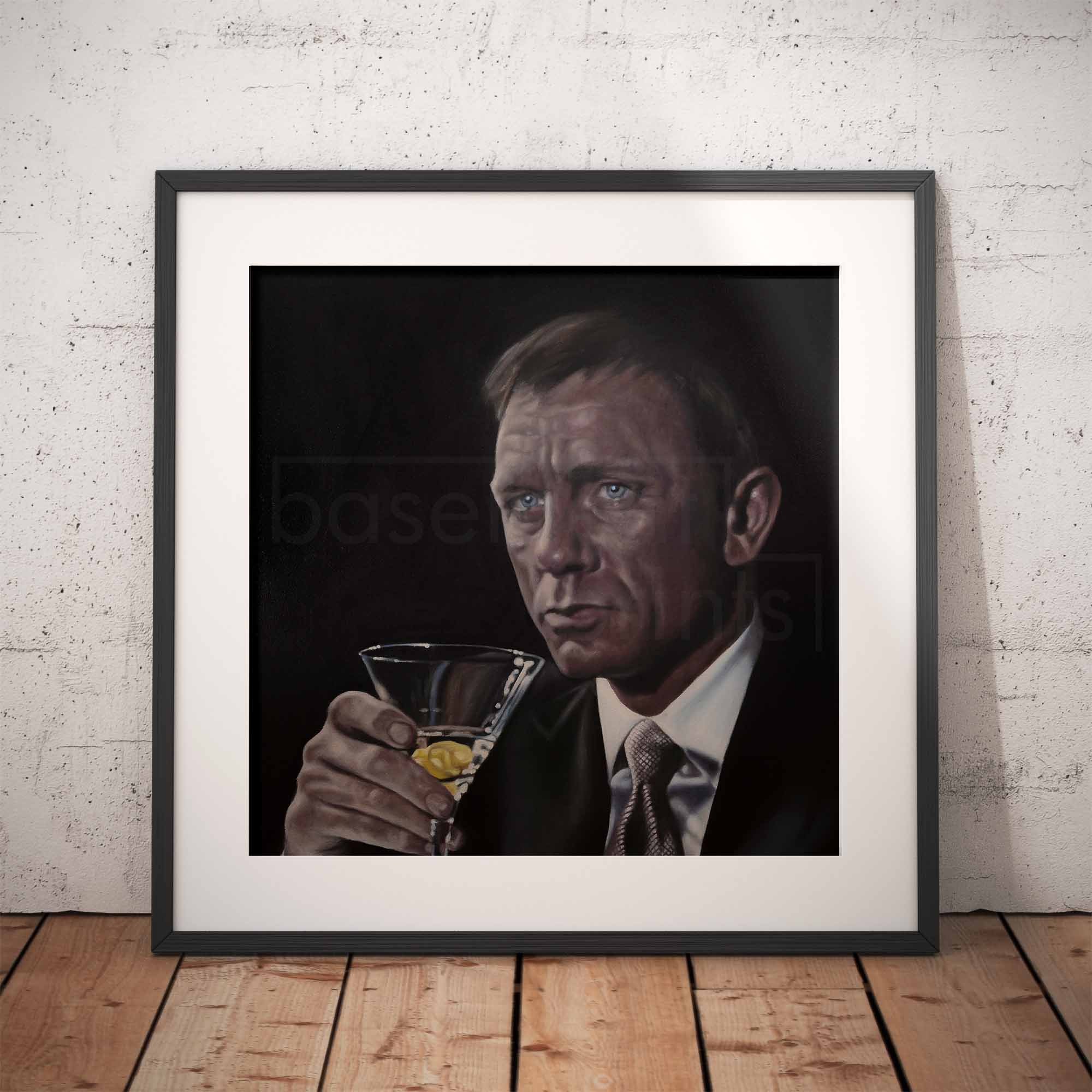Framed artwork of James Bond, Daniel Craig holding a martini glass against a white brick wall.