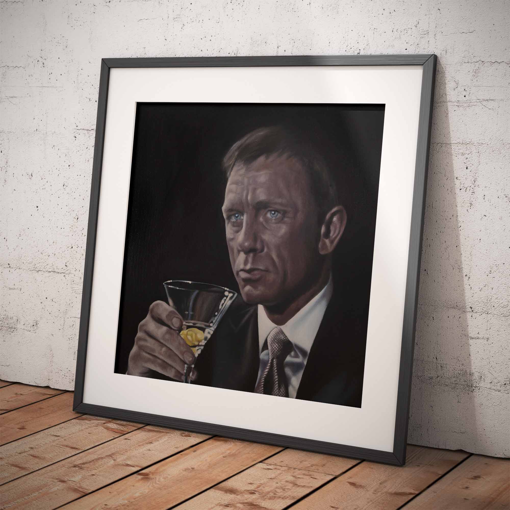Framed artwork of James Bond, Daniel Craig holding a glass against a white brick wall.