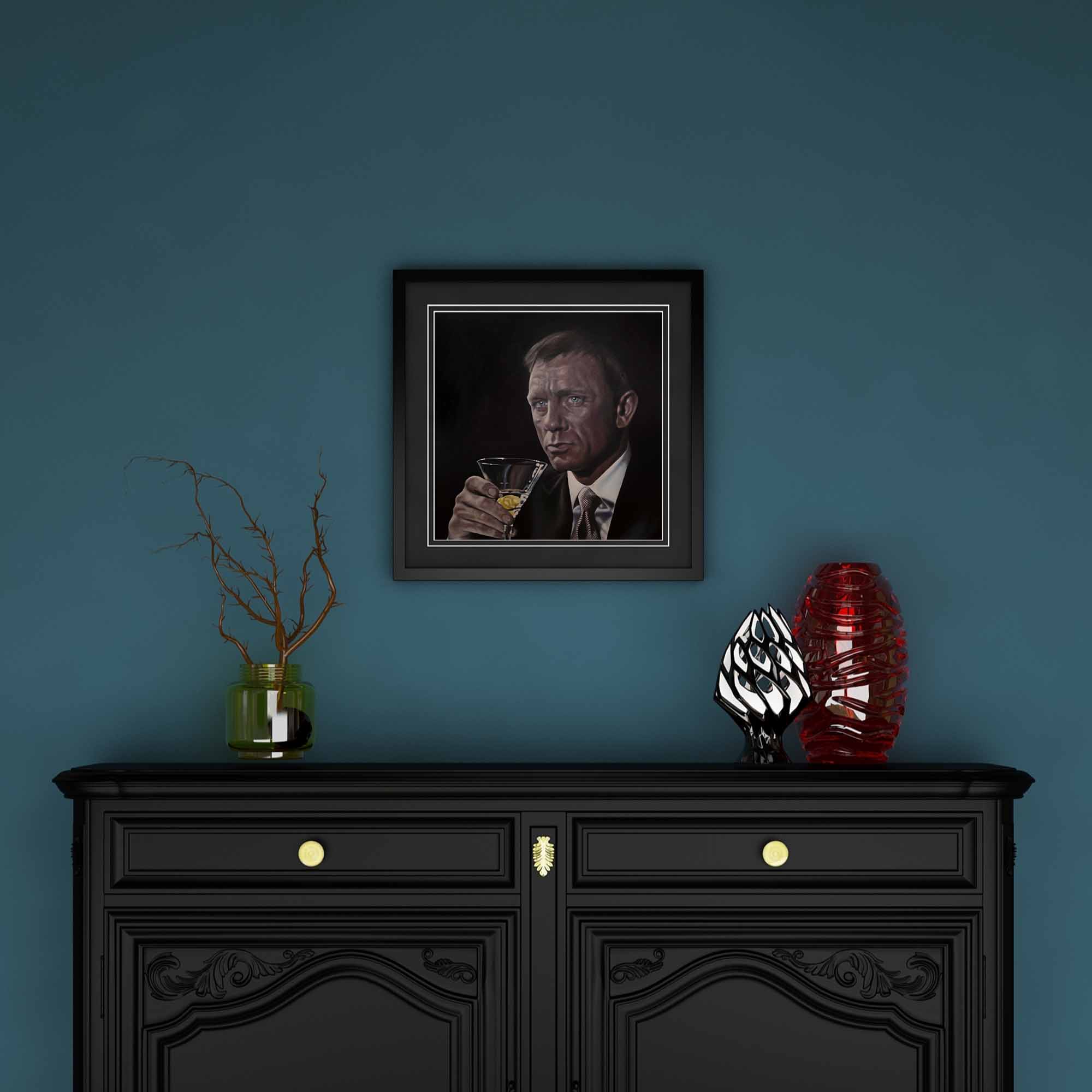 Framed portrait on a blue wall above a black cabinet with decorative items.