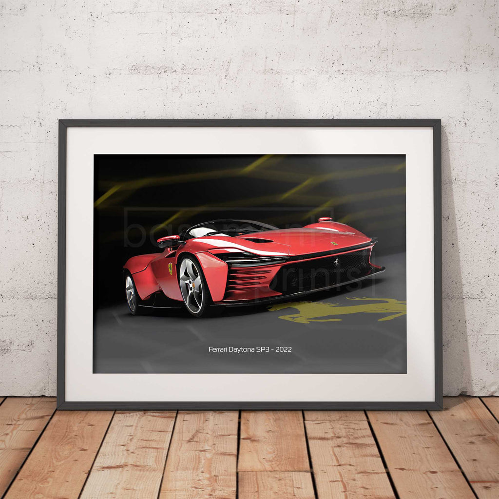 Framed artwork of a red Ferrari Daytona SP3 on a wooden floor with a white brick wall background.