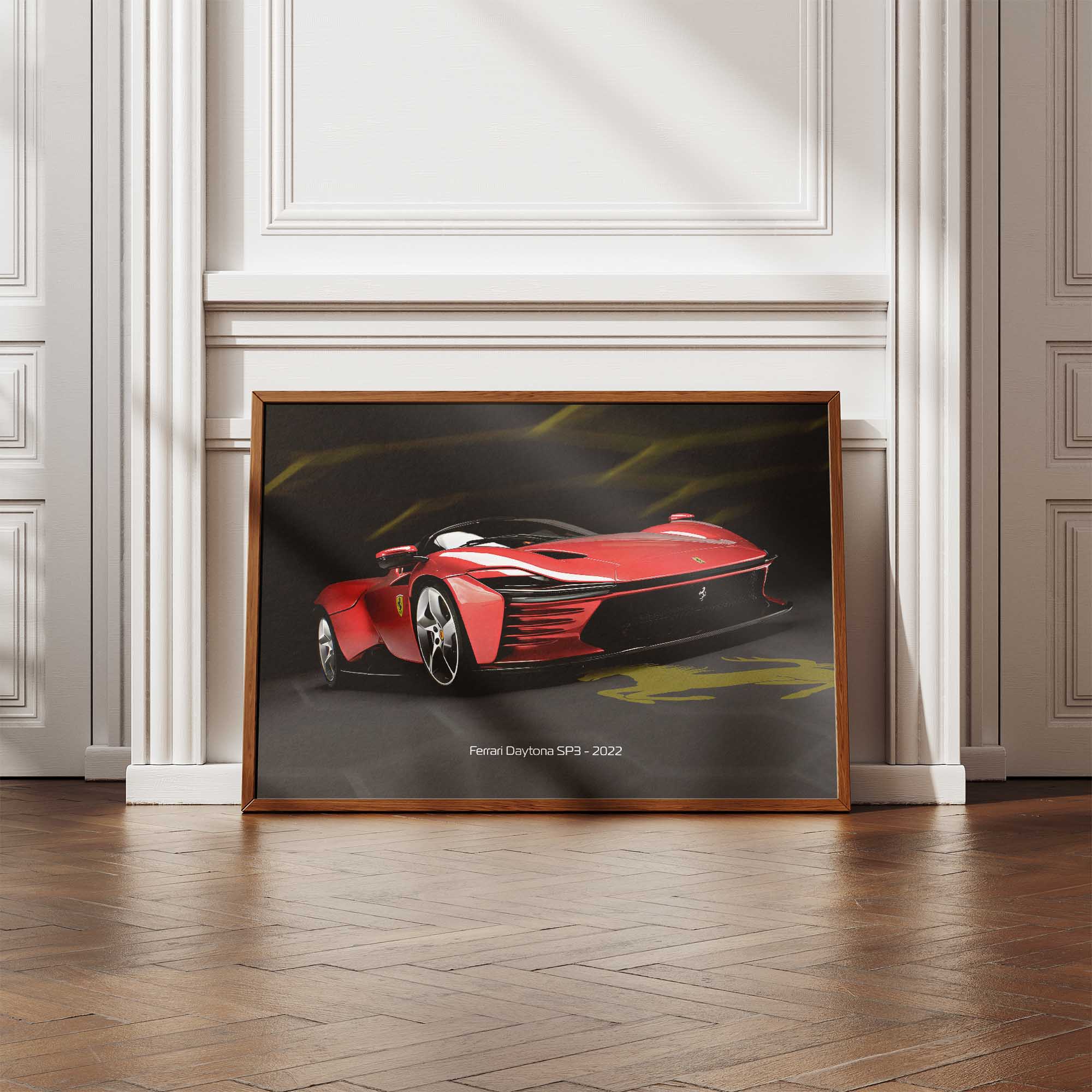 Framed poster of a red Ferrari SP3 on a wall in a room with wooden flooring.