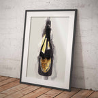 Framed artwork of a Dom Perignon champagne bottle on a white wall.