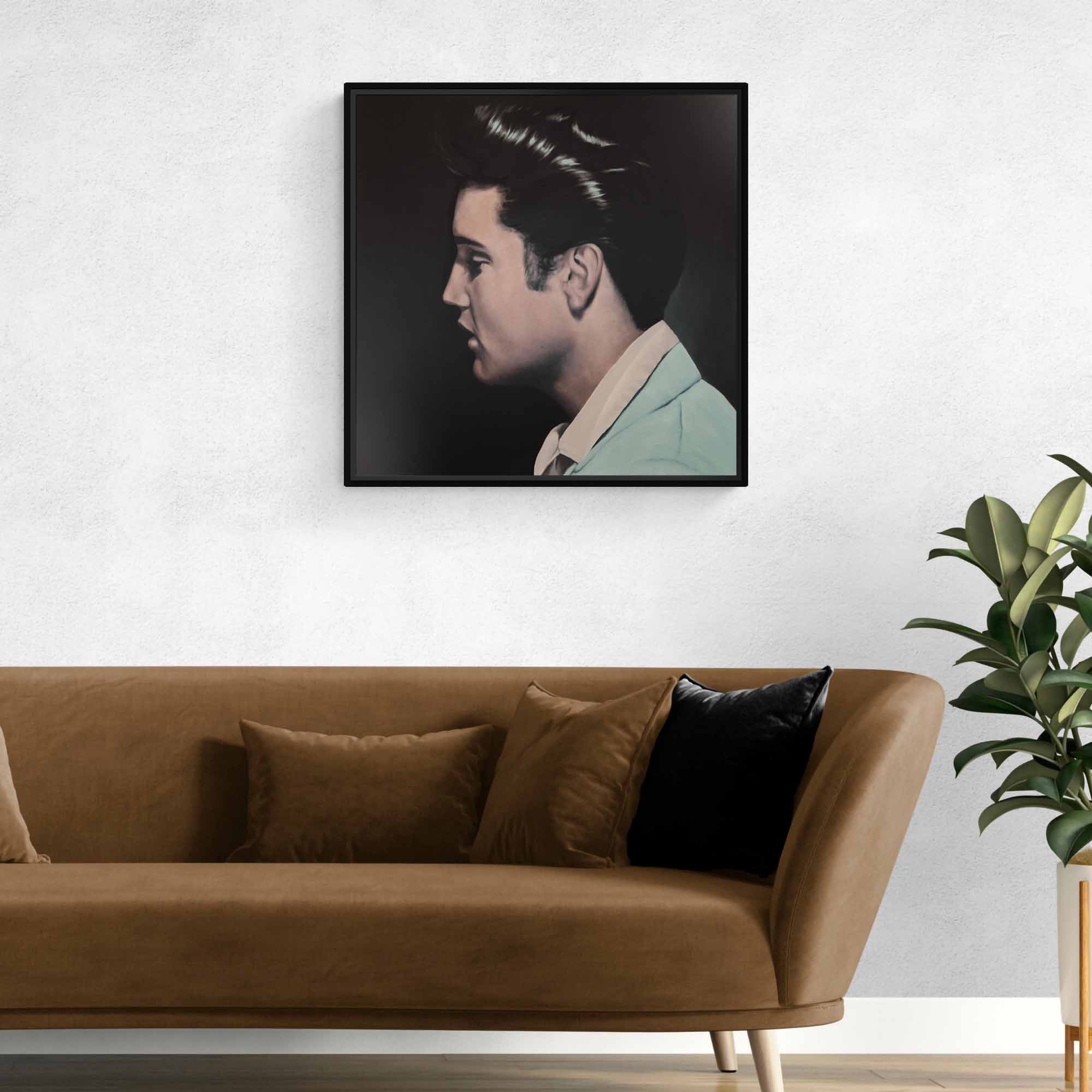Framed portrait of Elvis Presley above a brown sofa with decorative pillows in a living room setting.