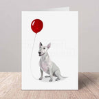 Greeting card with an English Bull Terrier holding a red balloon on a white background