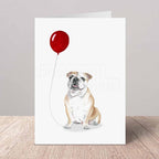 Greeting card with a bulldog holding a red balloon on a white background