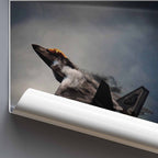 Rolled poster of an F22 Raptor jet with smoke against a gray sky, mounted on a wall.