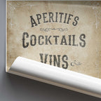 Vintage-style sign with text 'Aperitifs, Cocktails, Wines' on a textured background.