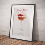Framed artwork of a French Martini cocktail on a white wall.