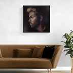 Framed portrait of George Michael above a brown sofa with decorative pillows in a living room setting.