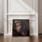 Framed portrait of George Michael on a white wall.