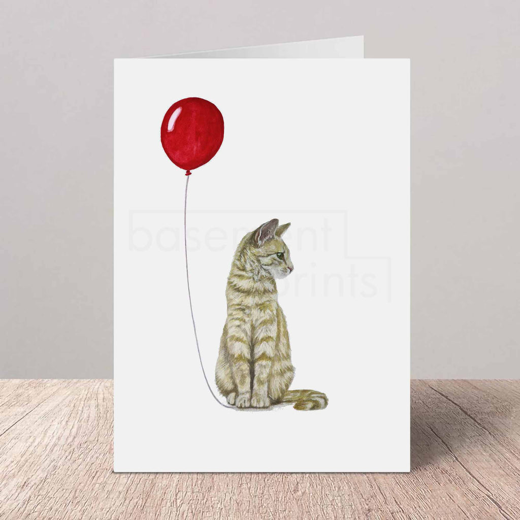 Greeting card with a ginger tabby cat and red balloon design on a white background