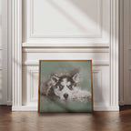 Framed artwork of a husky dog with blue eyes on a wall in a room with wooden flooring and white walls.