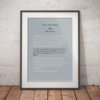 Framed text print of a quote from 'Pride and Prejudice' by Jane Austen on a light blue background, displayed against a white brick wall.
