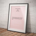 Framed print of 'Pride and Prejudice' by Jane Austen on a pink background against a white brick wall.
