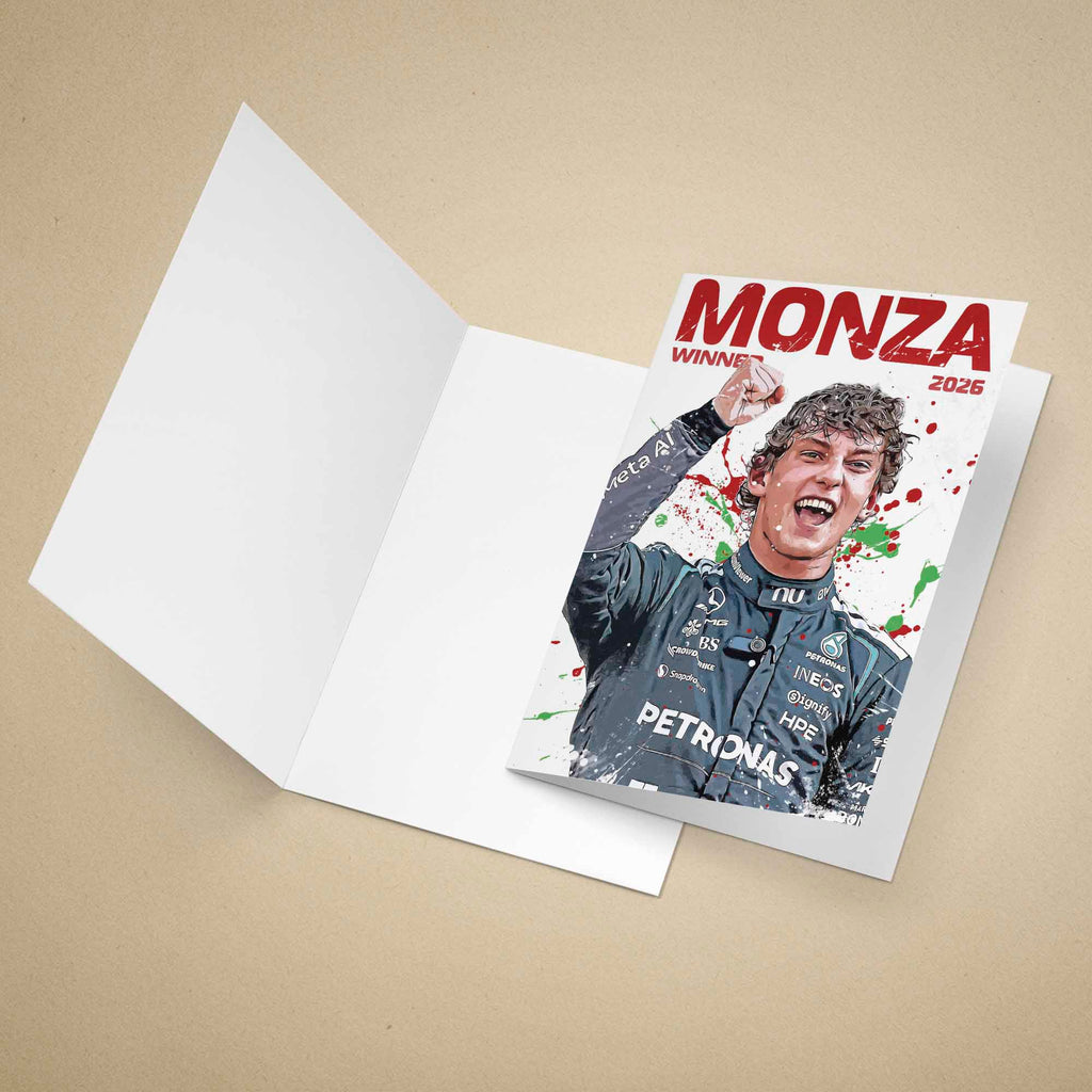 A folded white greeting card lies open on a beige background, with a printed front insert showing Kimi Antonelli in his race suit and the bold red text 'MONZA WINNER 2026' with paint-splatter accents.