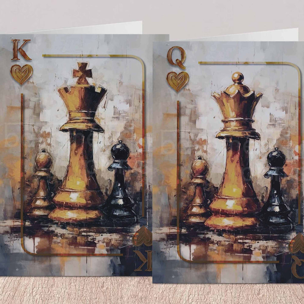 Two rectangular art greeting cards displayed side by side on a light beige surface. Each card features a painted scene of chess pieces, with a large gold-toned king and queen piece in the centre, smaller black and gold pieces around it, and playing-card style lettering in the corners.