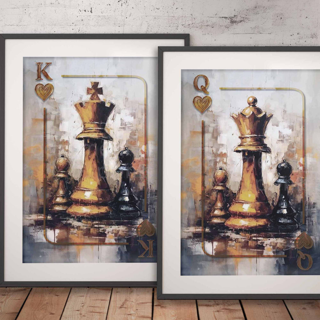 Two framed art prints leaning against a wall on a wooden floor. Each print shows a stylized chess queen and king scene with a large gold-toned queen chess piece, smaller black pieces, and playing-card-inspired corner marks reading K and Q with heart symbols.