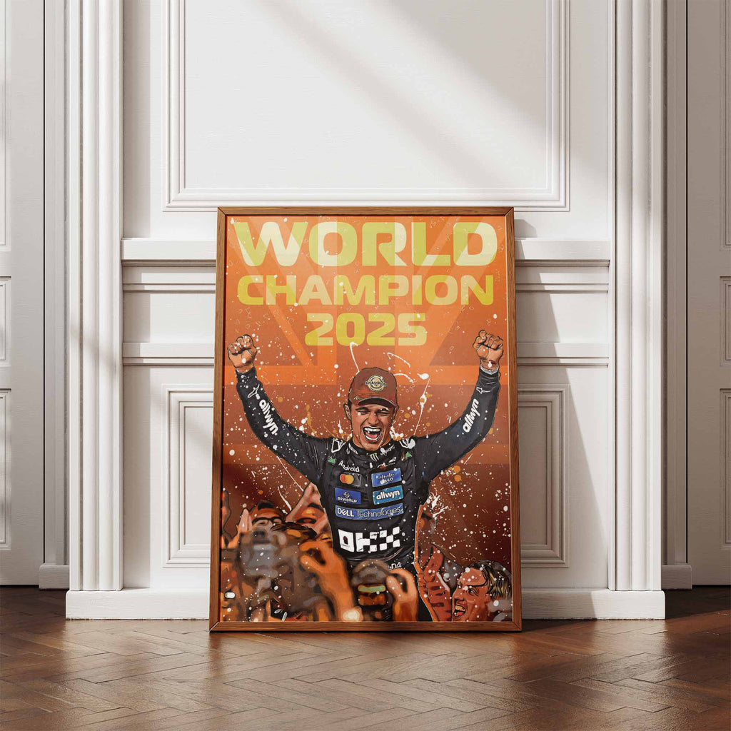 Framed artwork of Lando Norris celebrating the F1 World Championship 2025 leaning against a white panelled wall and wooden floor.