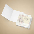 A greeting card set on a warm beige background, with the front insert showing a printed circuit map and text for the Formula 1 Spanish Grand Prix at Circuit de Madrig.