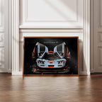 Framed print of a McLaren F1 GTR Gulf racing car on a white wall with wooden floor.