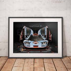 Framed poster of a McLaren F1 GTR Gulf racing car on a white wall with wooden floor.