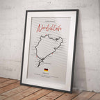 Framed poster of a race track layout with 'Nordschleife' on a white brick wall background.