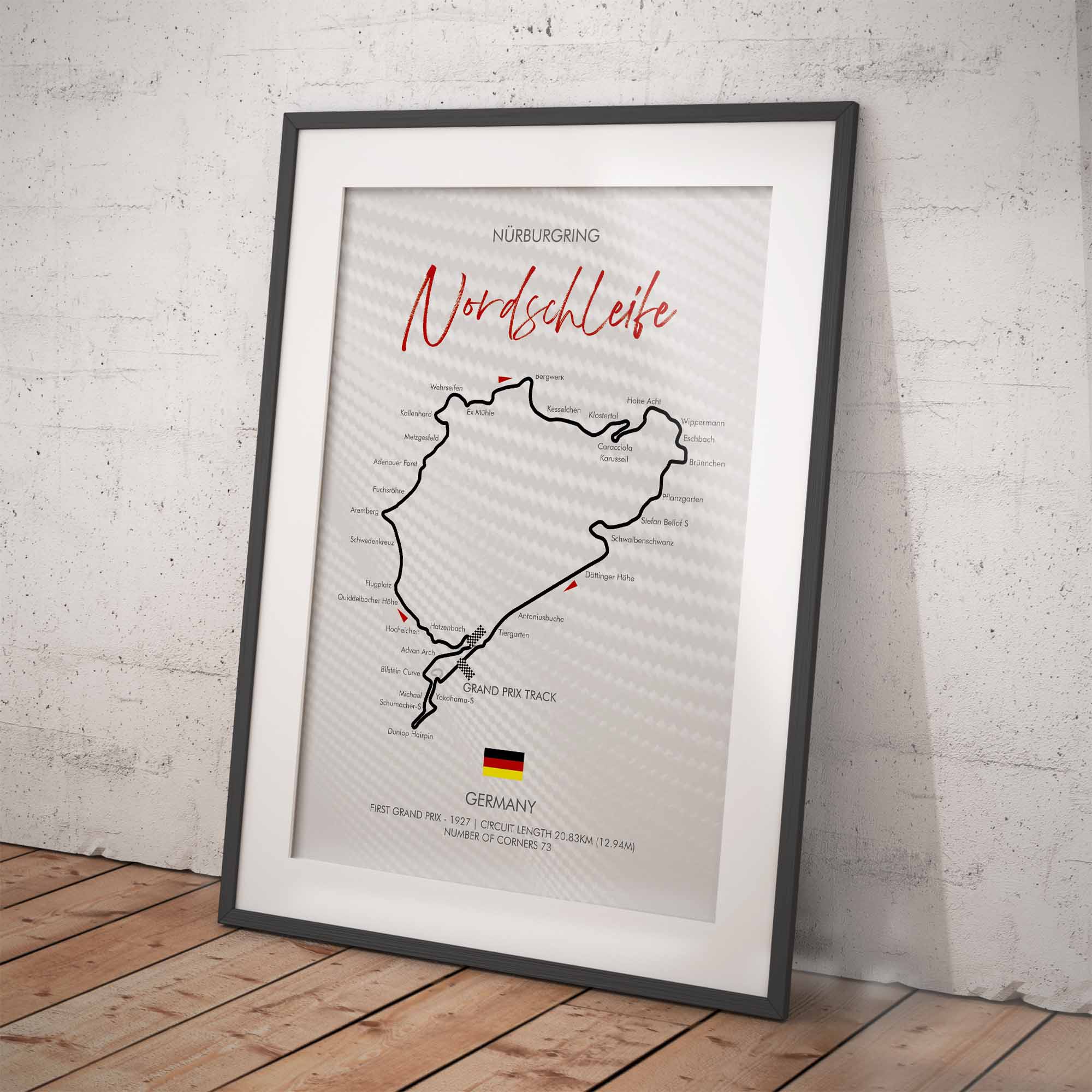 Framed poster of a race track layout with 'Nordschleife' on a white brick wall background.