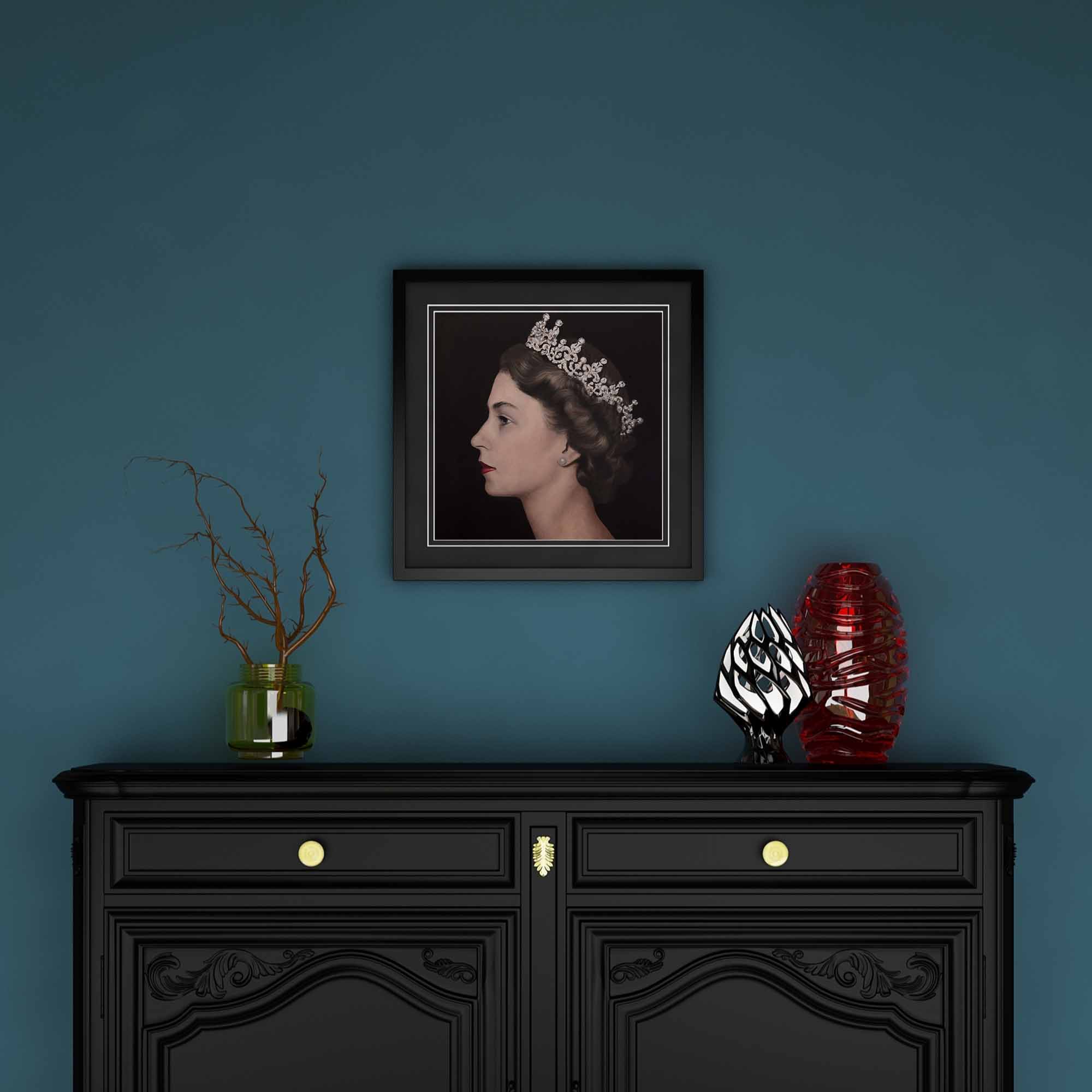 Framed artwork of Queen Elizabeth II above a black cabinet with decorative items against a blue wall