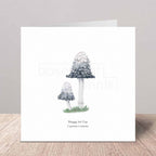 Greeting card with illustration of shaggy ink cap mushrooms on a wooden surface.