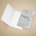 A printed greeting card featuring a stylized Suzuka International Racing Course map with numbered turns, red script title 'Suzuka,' and course text, standing on a warm beige background.