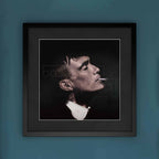Framed artwork of Thomas Shelby smoking a cigarette on a blue wall.