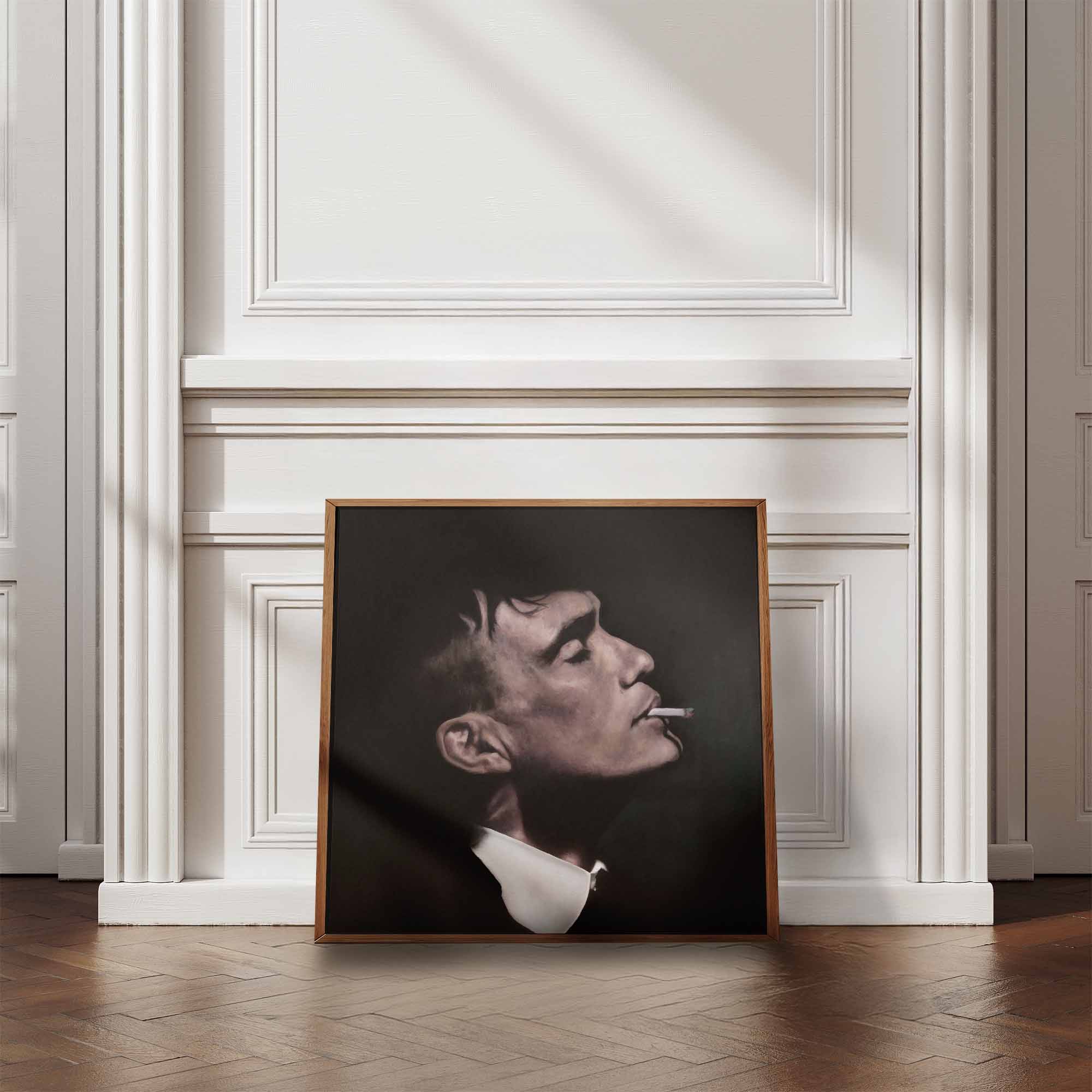 Framed portrait of Thomas Shelby smoking a cigarette on a wall with decorative molding.