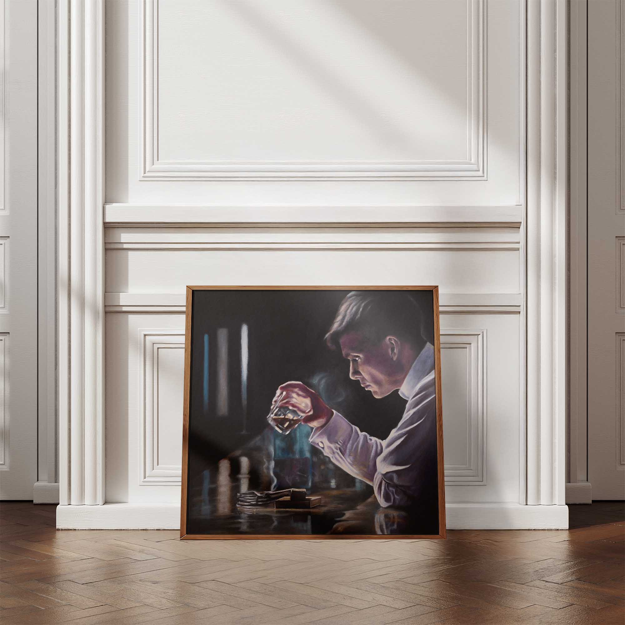Framed artwork of a person holding a glass against a white wall.