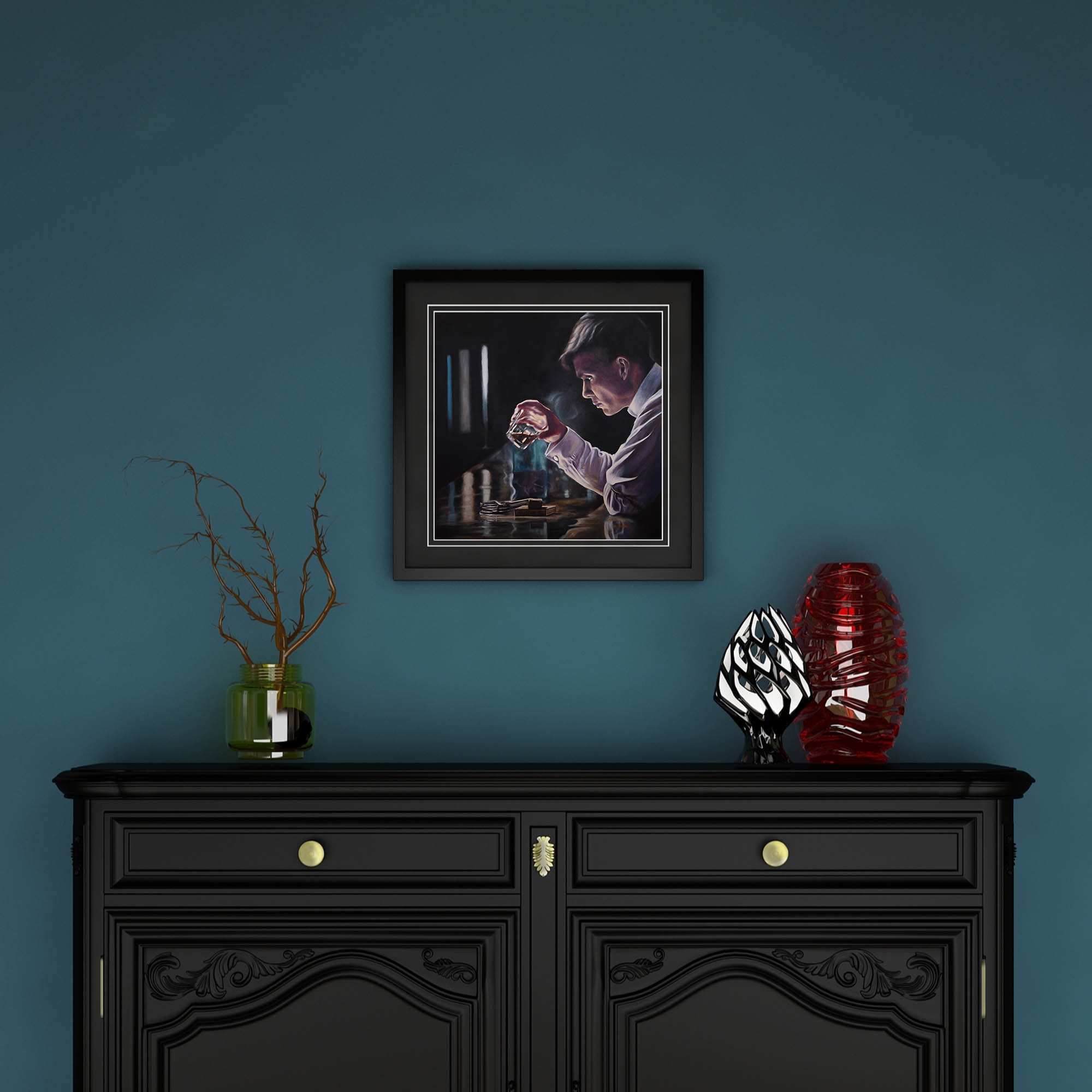 Framed artwork above a black cabinet with decorative items on a teal wall