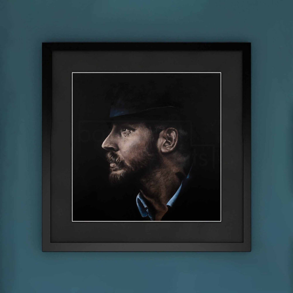 Framed portrait of Tom Hardy with a dark background on a blue wall