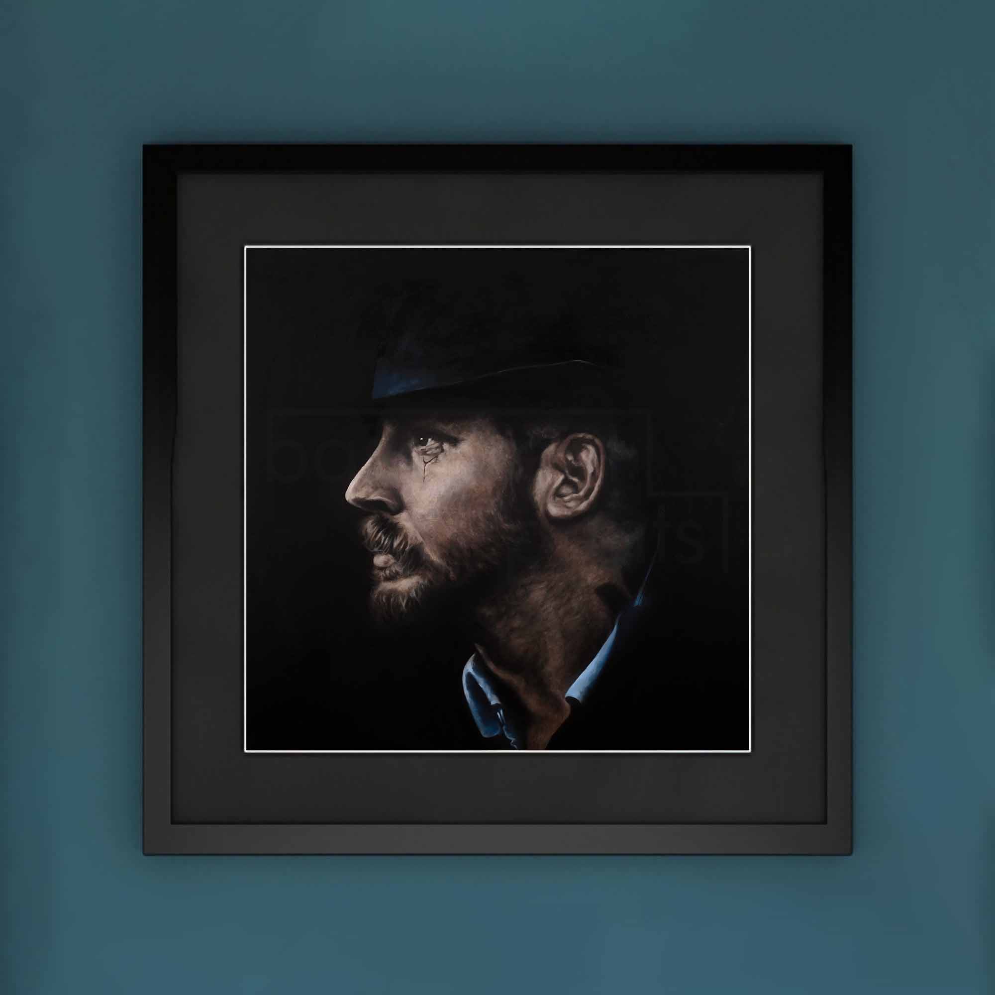 Framed portrait of Tom Hardy with a dark background on a blue wall