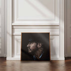 Framed portrait of Tom Hardy on a wall in a room with wooden flooring and white walls.