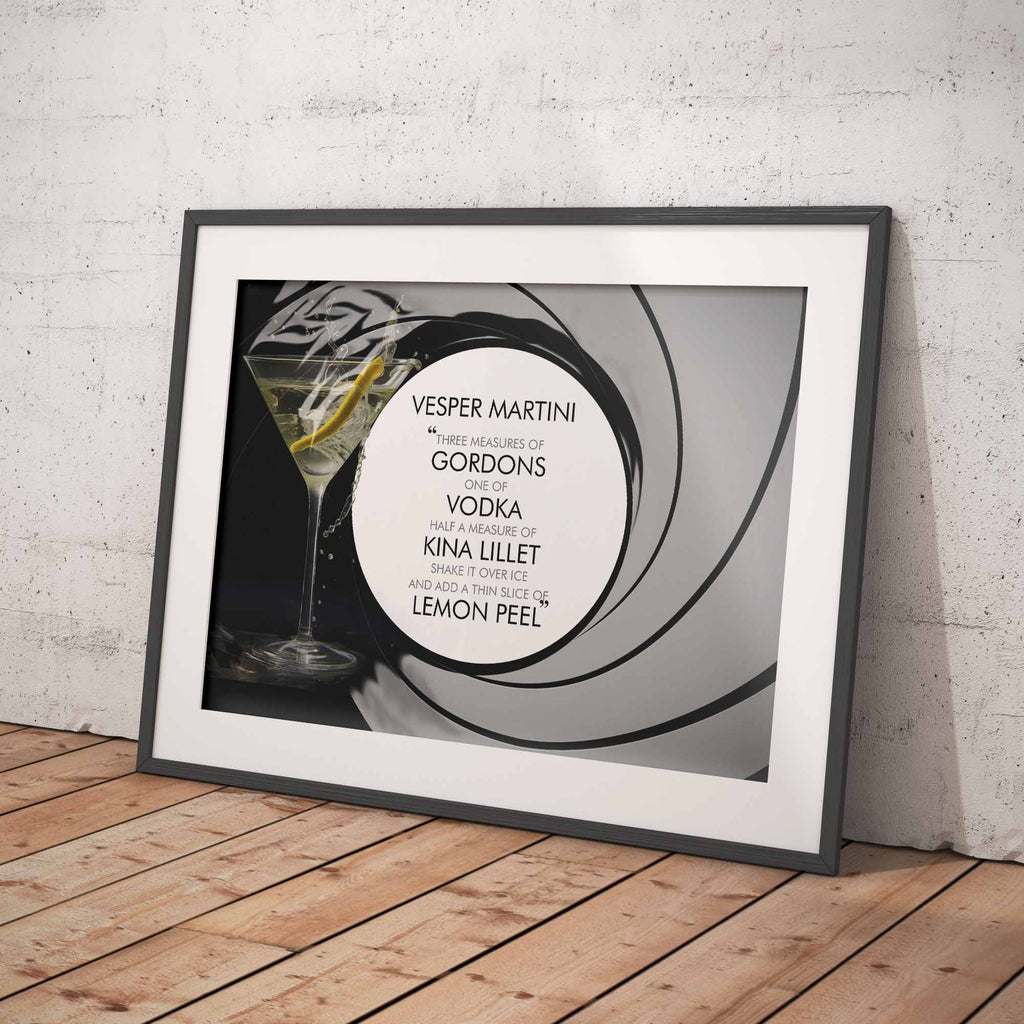 Framed Vesper Martini cocktail recipe on a wooden floor against a white brick wall